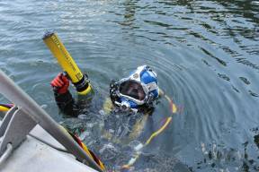 A diver holding a CT-1 Probe while on the water