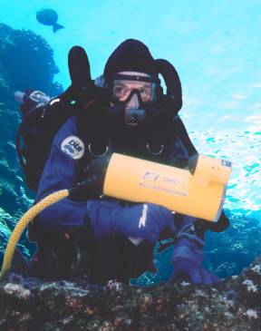 A diver under water using a Diver Held Camera (DHC)
