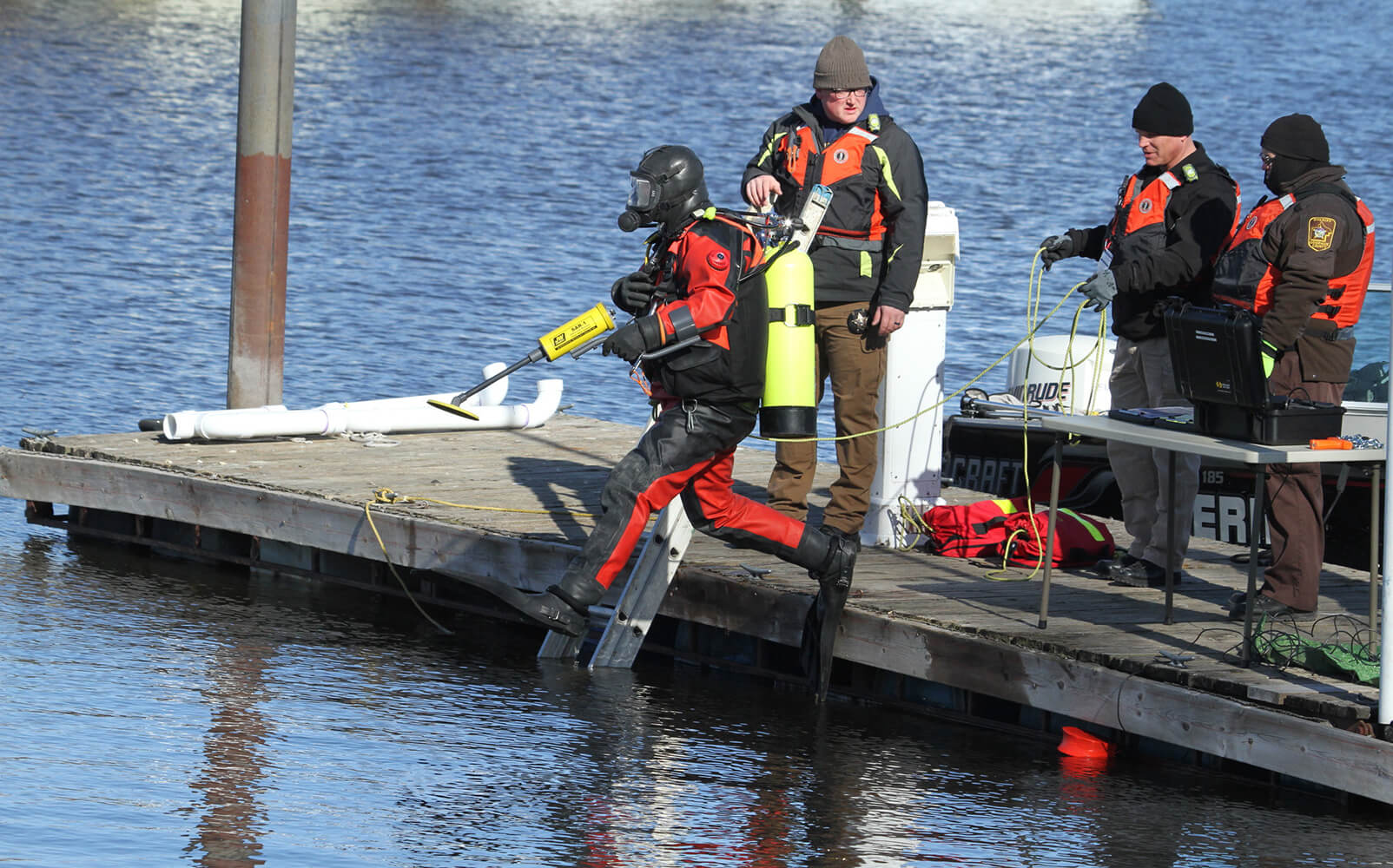 Diver about to dive while holding Search And Recovery Metal Detector (SAR)