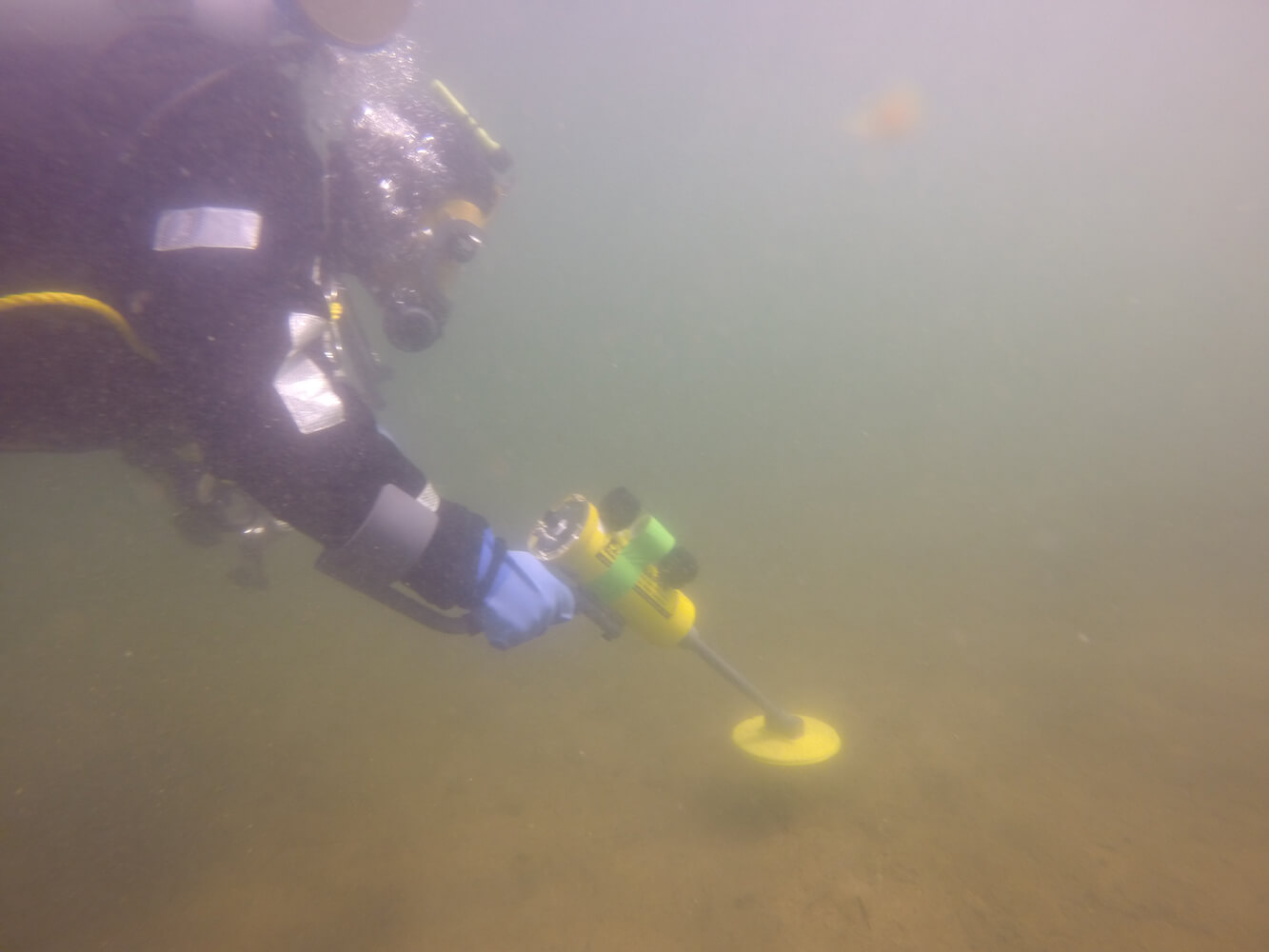 Diver under water using Search And Recovery Metal Detector (SAR)